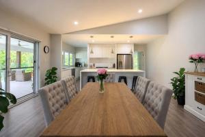 a kitchen and dining room with a wooden table and chairs at Spacious 6BR Mansion with Pool Sauna BBQ in Gold Coast