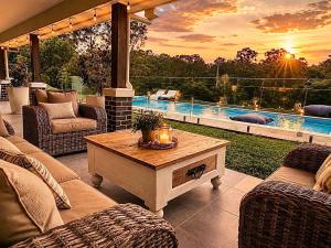 a patio with couches and a table and a pool at Spacious 6BR Mansion with Pool Sauna BBQ in Gold Coast