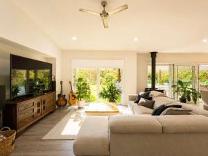a living room with a couch and a flat screen tv at Spacious 6BR Mansion with Pool Sauna BBQ in Gold Coast +34 photos