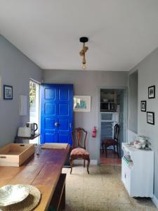 a living room with a blue door and a table at Casa de las Ascuas in Ourense