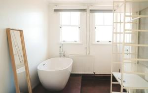 a white bath tub in a room with two windows at Hill House butik in Istanbul