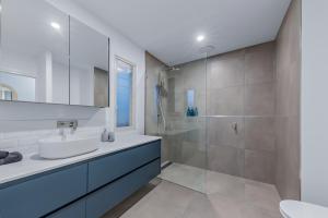 a bathroom with a sink and a shower at Seabreeze Lookout Azul in Airlie Beach +37 photos