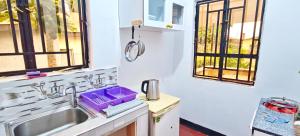 a kitchen with a sink and two windows at Dans place in Moshi +30 photos