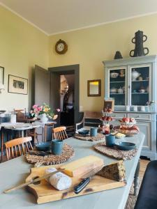 a table with plates and bowls on top of it at Le Jardin De Gustave in Ornans