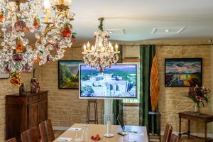 a dining room with a table and a chandelier at Logis Hôtel La Bastide De Grignan & Restaurant La Chênaie in Grignan