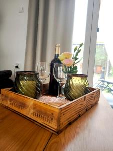 a wooden tray with two glasses and a bottle of wine at Siedlisko Niwy in Łęki Szlacheckie