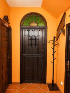 a large black door in a room with an orange wall at La Mío Quintana in Corao