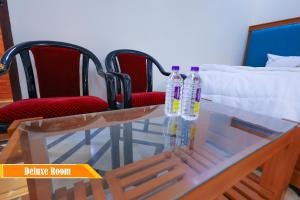 two bottles of water on a glass table with chairs at Mount Zion Holidays in Kuttālam