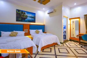 a bedroom with two beds and a tv in it at Mount Zion Holidays in Kuttālam