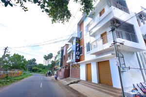 a white building on the side of a street at Mount Zion Holidays in Kuttālam
