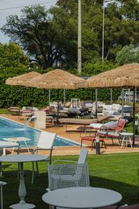 a group of chairs and tables and umbrellas next to a pool at Casale Incanto in Terracina