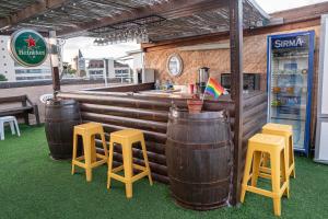 Eine Bar mit drei Holzfässern und Hockern in der Unterkunft Hotel Loui Talpiot in Haifa