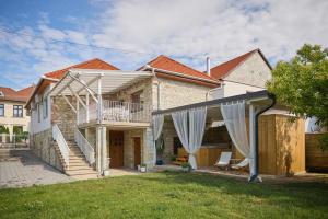 a brick house with a balcony and a patio at Szarka DownTown Vendégház in Mád