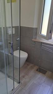 a bathroom with a toilet and a glass shower at La casa al mare in Marcelli