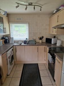 a kitchen with a sink and a washing machine at Chalet 85 in Caeathro