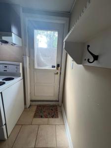 a small kitchen with a white door and a window at Luxurious Vacation in Welland