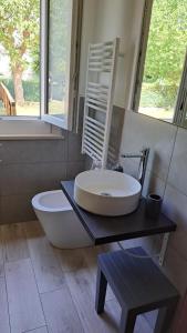 a bathroom with a sink and a toilet and a window at La casa al mare in Marcelli