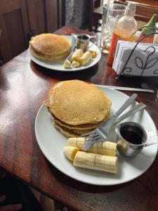 two plates of pancakes and bananas on a table at Sunny Garden Lodge in Mérida