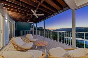 a balcony with chairs and a table with a view at Seabreeze Lookout Azul in Airlie Beach