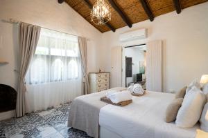 ein Schlafzimmer mit einem großen weißen Bett und einem Fenster in der Unterkunft Monte Borboleta - Villas, Apartments in Faro