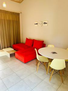 a living room with a red couch and a table at Glikis Ear Apartments in Gliki