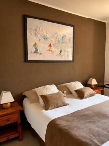 a bedroom with two beds and a painting on the wall at Hôtel Le Chastellan in Valberg
