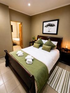 a bedroom with a large bed with towels on it at Lloyds - 6 in Ermelo