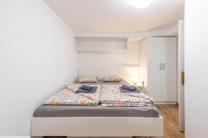 a bedroom with a bed in a white room at Poli in Šmarje-Sap