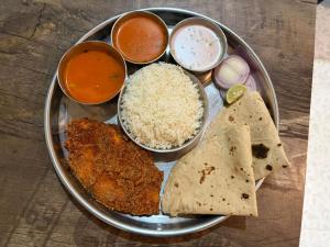 a plate of food with rice and other food items at SH Guest House Malvan in Malvan
