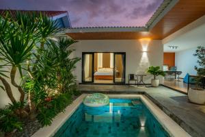 a villa with a swimming pool and a bedroom at Villa Dake Tanah Lot in Tanah Lot