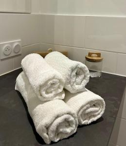 a pile of white towels sitting on the floor of a bathroom at EKR Résidence - Terrasse Privée 2 in Carbon-Blanc +56 photos