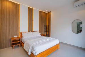 a bedroom with a bed and a mirror at Villa Dake Tanah Lot in Tanah Lot