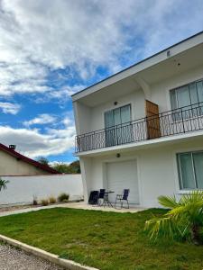 a white house with two chairs and a balcony at EKR Résidence - Terrasse Privée 2 in Carbon-Blanc