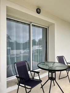 a table and chairs in a room with a window at EKR Résidence - Terrasse Privée 2 in Carbon-Blanc