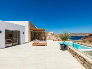 a villa with a swimming pool and a patio at Vinara Luxury Suites Mykonos in Mykonos