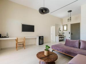a living room with a purple couch and a table at Vinara Luxury Suites Mykonos in Mykonos