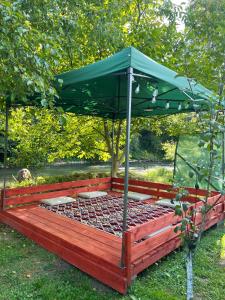 a bed with a green canopy in the grass at Apartman Elma in Jajce