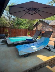 a hammock and an umbrella next to a pool at La Bella Vita Marloth Park in Marloth Park