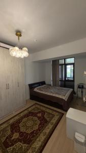 a bedroom with a large bed and a chandelier at Радуга in Chon-Sary-Oy