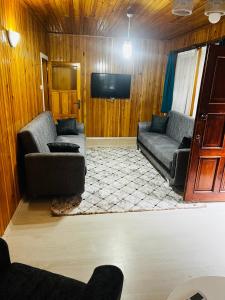 a living room with two couches and a flat screen tv at ZEREN APART 2 CENTRUM in Uzungöl