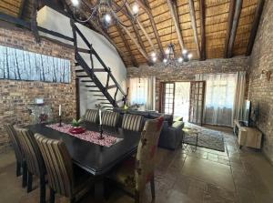 a dining room with a black table and chairs at La Bella Vita Marloth Park in Marloth Park