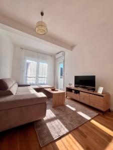 a living room with a couch and a flat screen tv at Apartman ART Foca in Foča