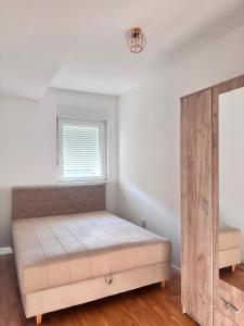 a bedroom with a bed and a wooden cabinet at Apartman ART Foca in Foča