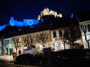 a building with a castle on top of it at night at Apartmán pod hradom B in Trenčín