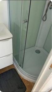 a shower with a glass door and a black rug at Escale Confort A1-2 Chambres Stationnement Facile in Roye