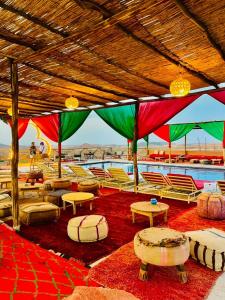 a room with chairs and tables and a pool at Maison-Lala Takerkoust et agafay in Lalla Takerkoust
