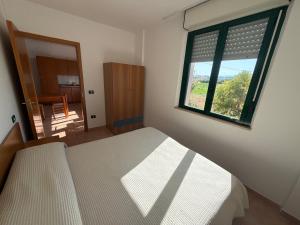 a bedroom with a bed and a large window at Polena Residence Hotel in Marina di Montenero +4 photos
