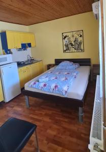 a small bedroom with a bed and a kitchen at Oázis Apartman in Harkány