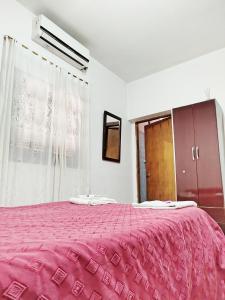 a bedroom with a large bed with a pink blanket at Casa Luis del carmen in Fiambalá