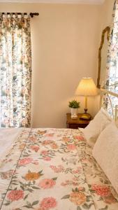 a bedroom with a bed with a floral bedspread at Hemithea Nidri Rooms in Nydri